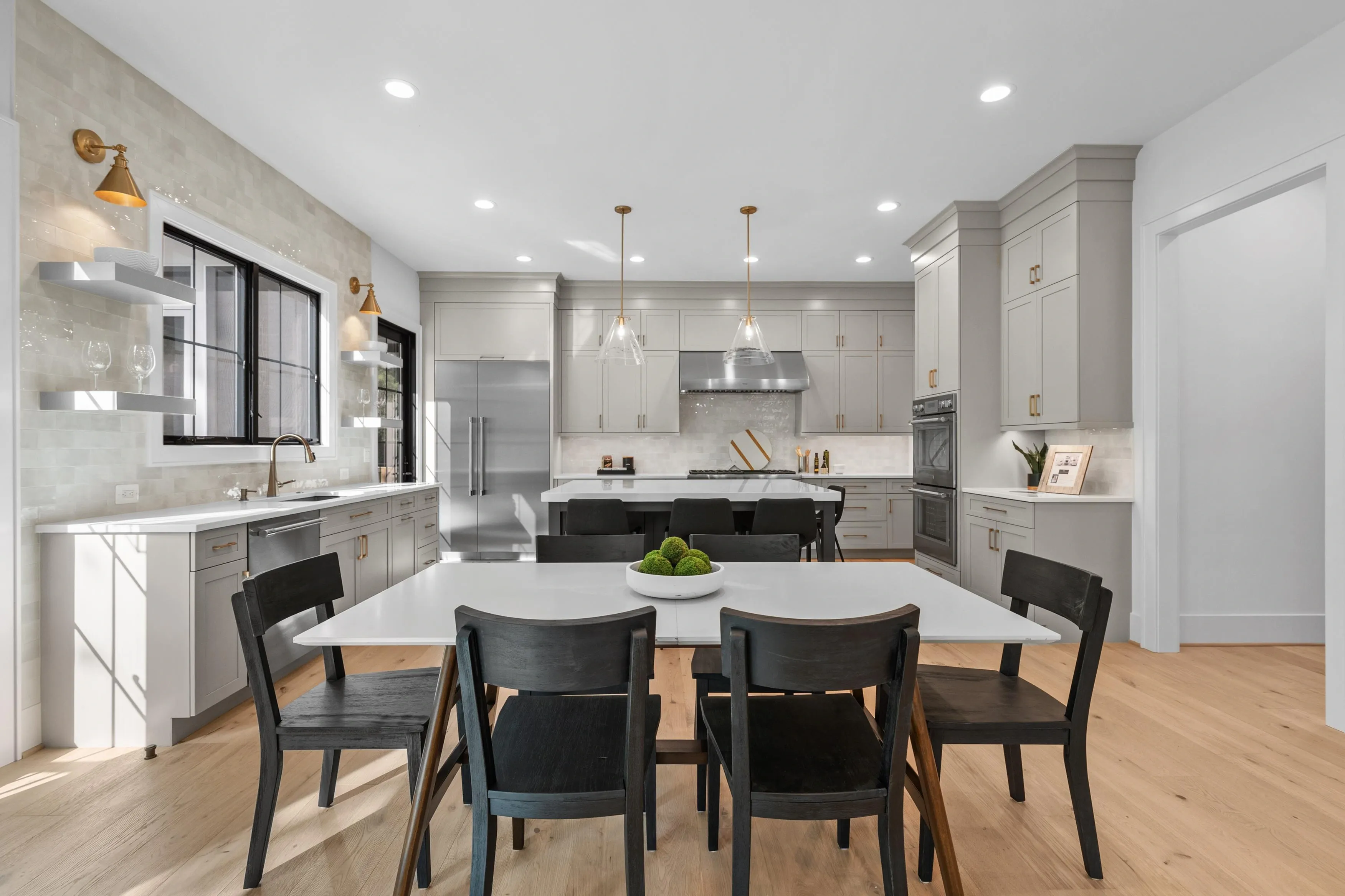 Kitchen island with seating, sage cabinetry, and stainless steel appliances
