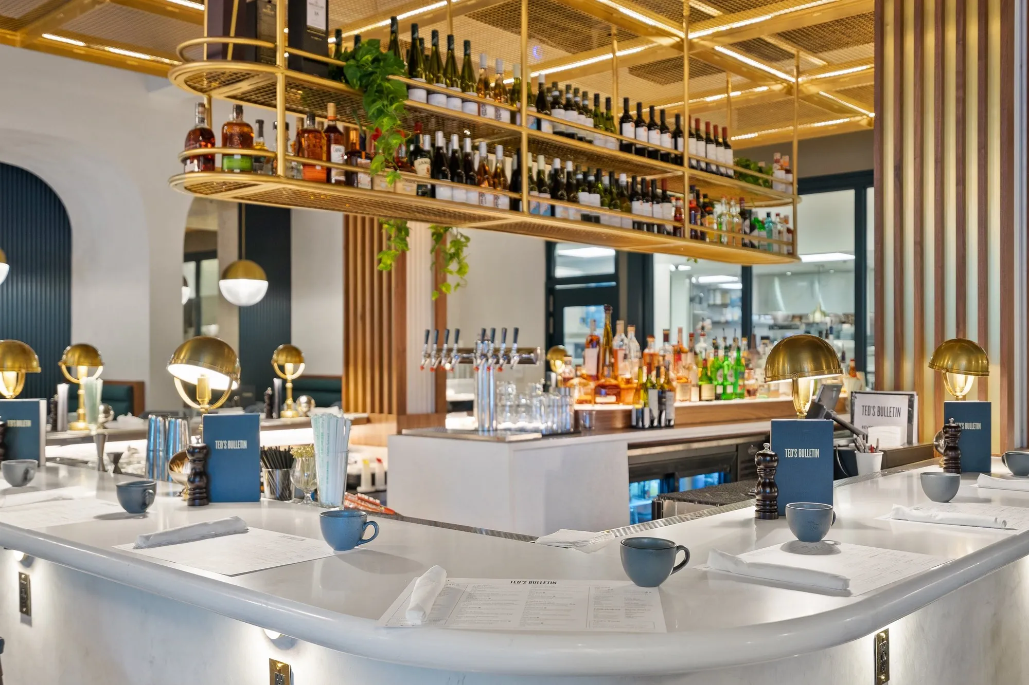 Upscale restaurant bar with brass shelving and marble counter — commercial restaurant photography by Umedia