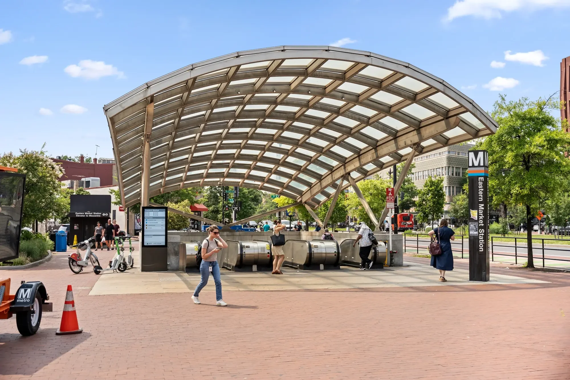Eastern Market Metro station entrance with escalators, Capital Bikeshare, and commuters, Washington, DC