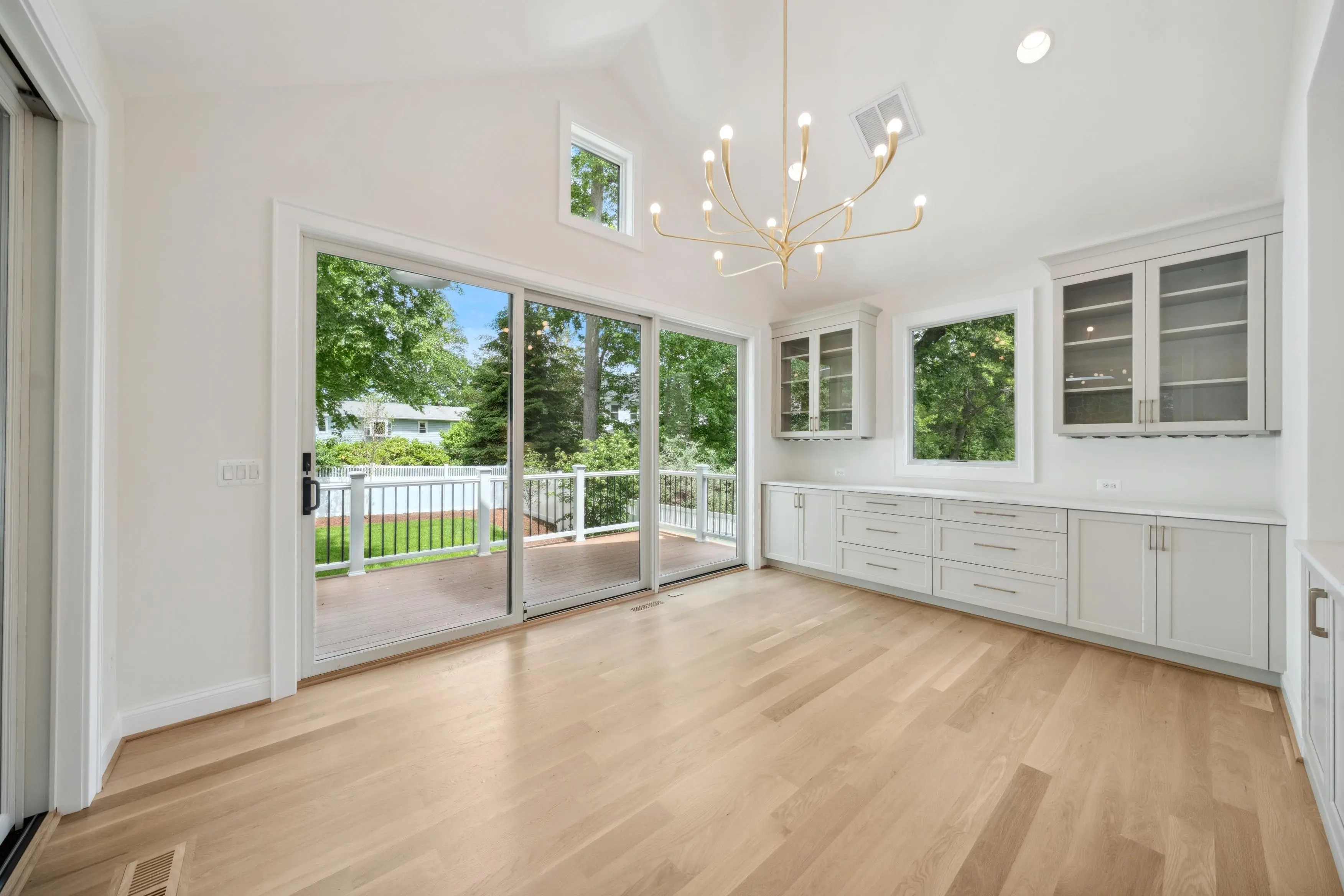 Interior real estate photography of a bright dining area with chandelier, built-in cabinetry, and garden view in Silver Spring Maryland