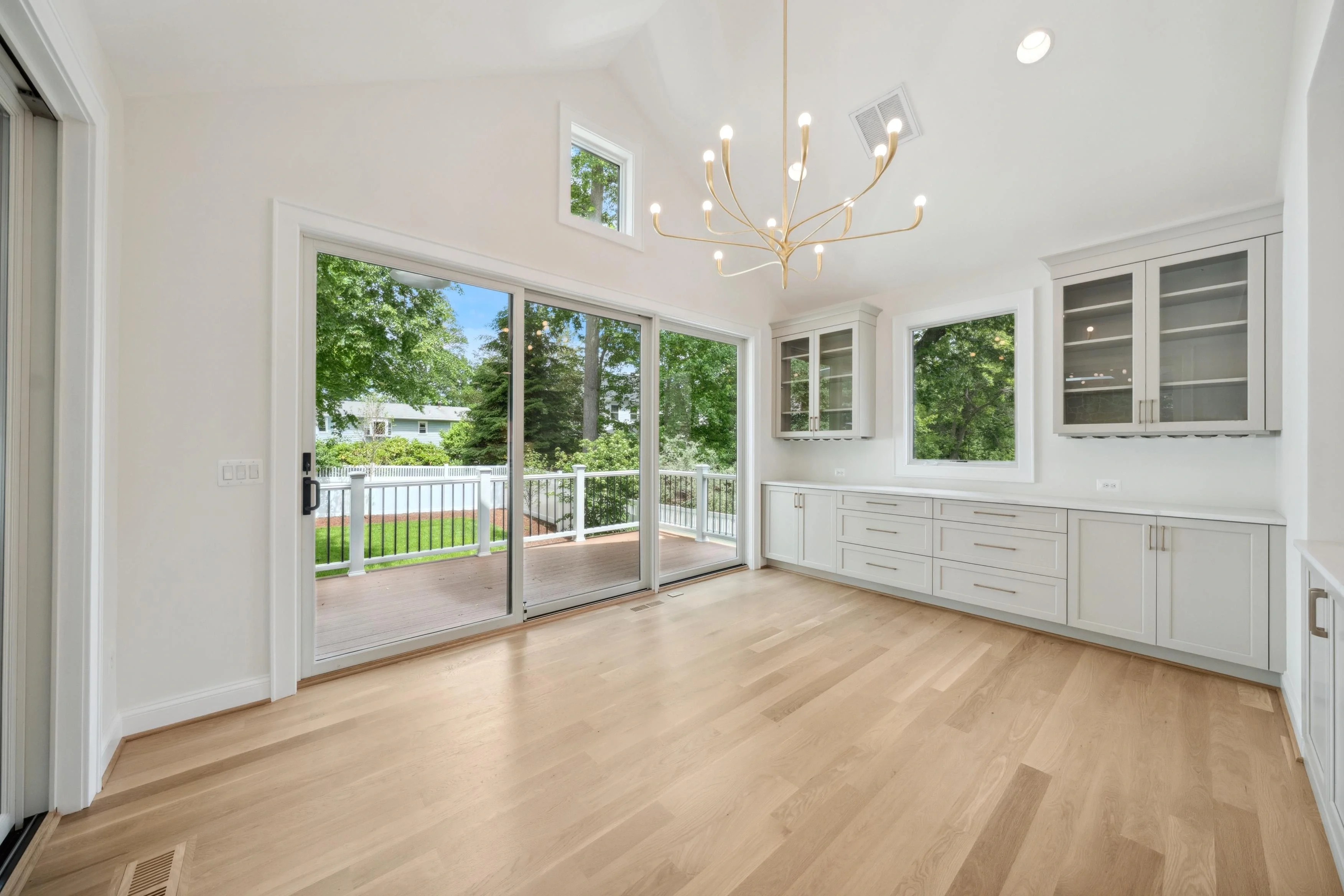Interior real estate photography of a bright dining area with chandelier, built-in cabinetry, and garden view in Arlington Virginia by Umedia