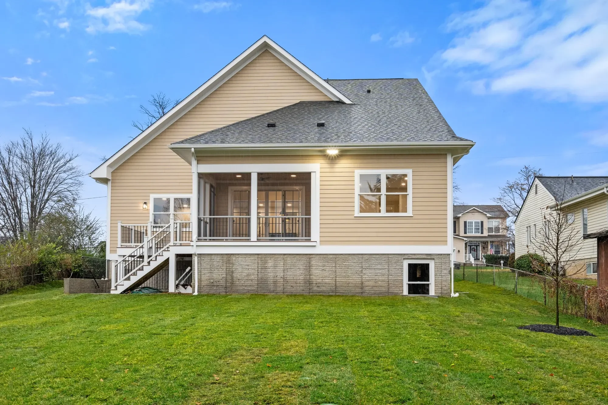 Rear exterior of a newly built Falls Church, VA home with screened porch and freshly sodded backyard