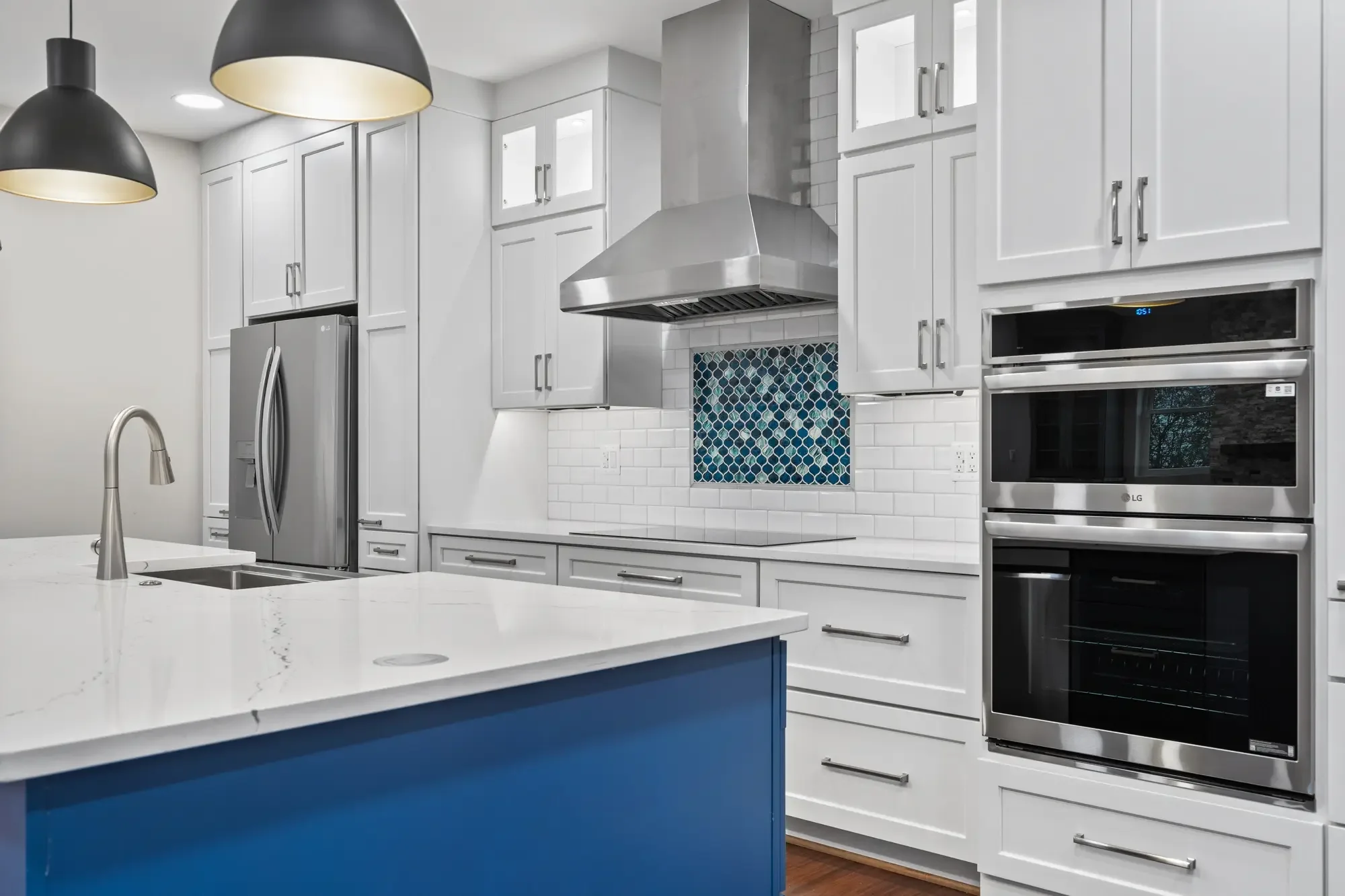 Rental kitchen with stainless steel appliances, blue island, and arabesque tile accent in Falls Church, VA
