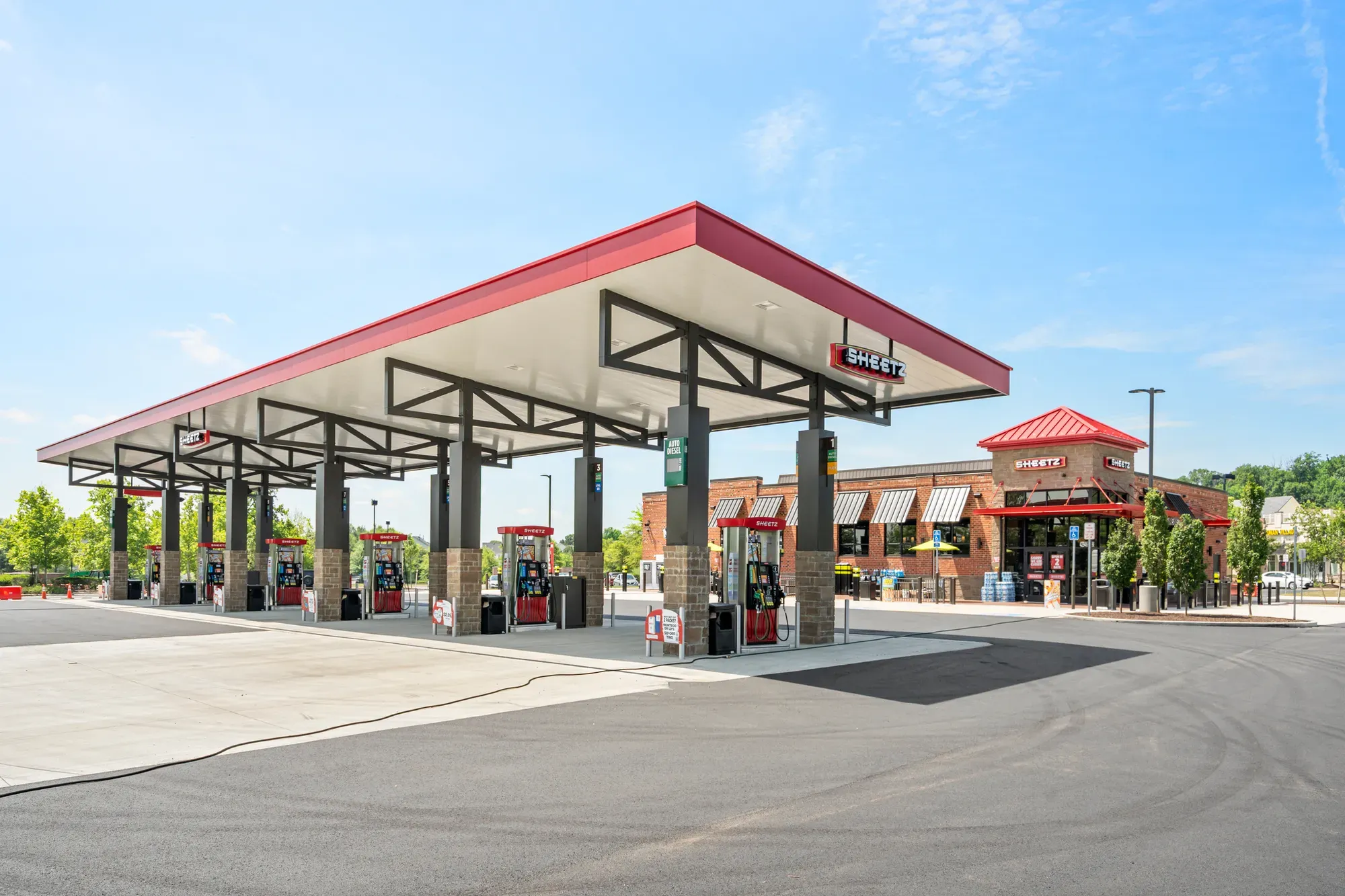 Newly built gas station fuel canopy and convenience store exterior under a clear sky — commercial exterior photography by Umedia