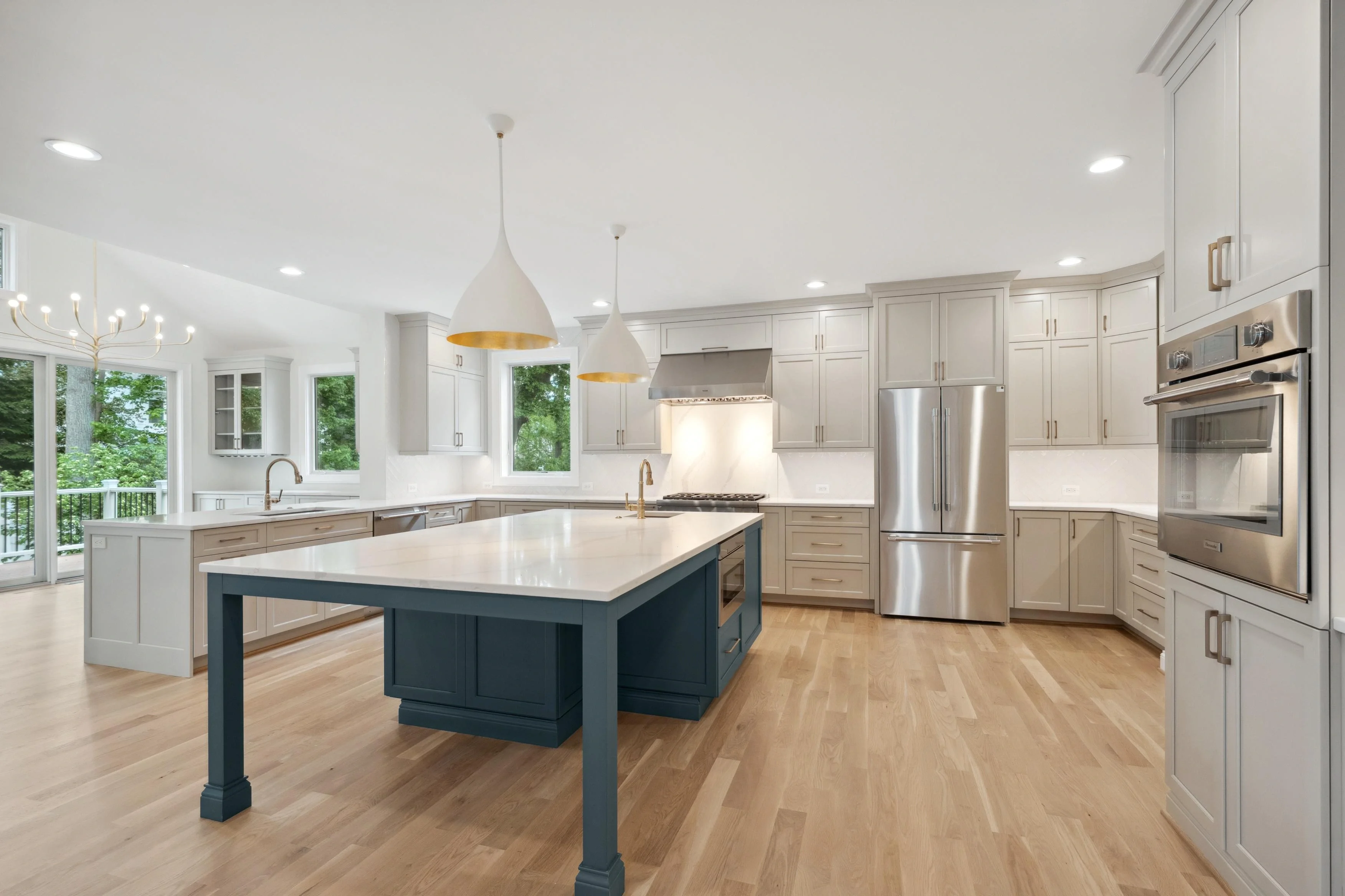 Professional HDR photography of a luxury kitchen with large island, pendant lighting, and stainless steel appliances in Arlington Virginia by Umedia