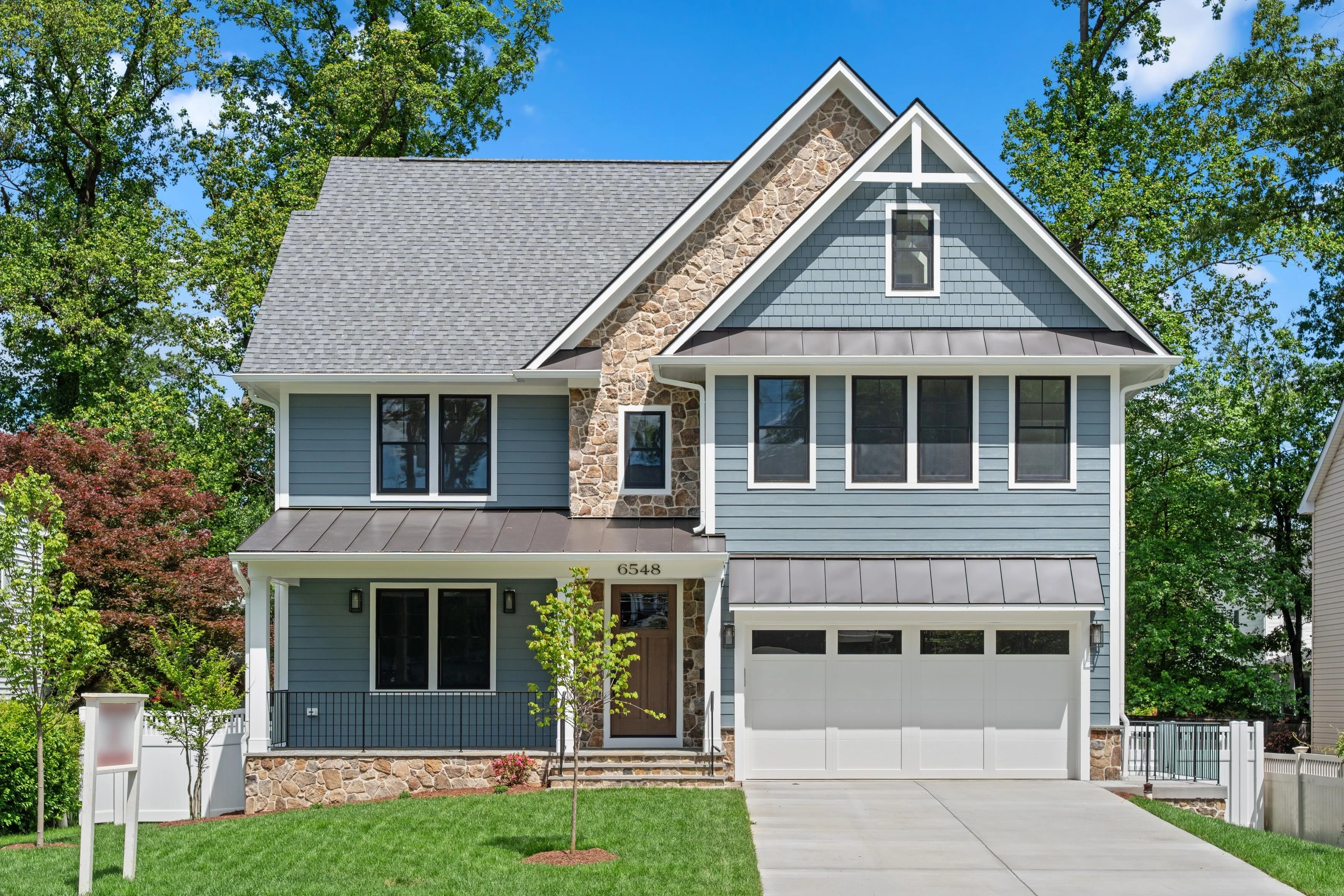 Exterior real estate photography of a modern craftsman-style home with blue siding and stone accents in Arlington Virginia by Umedia