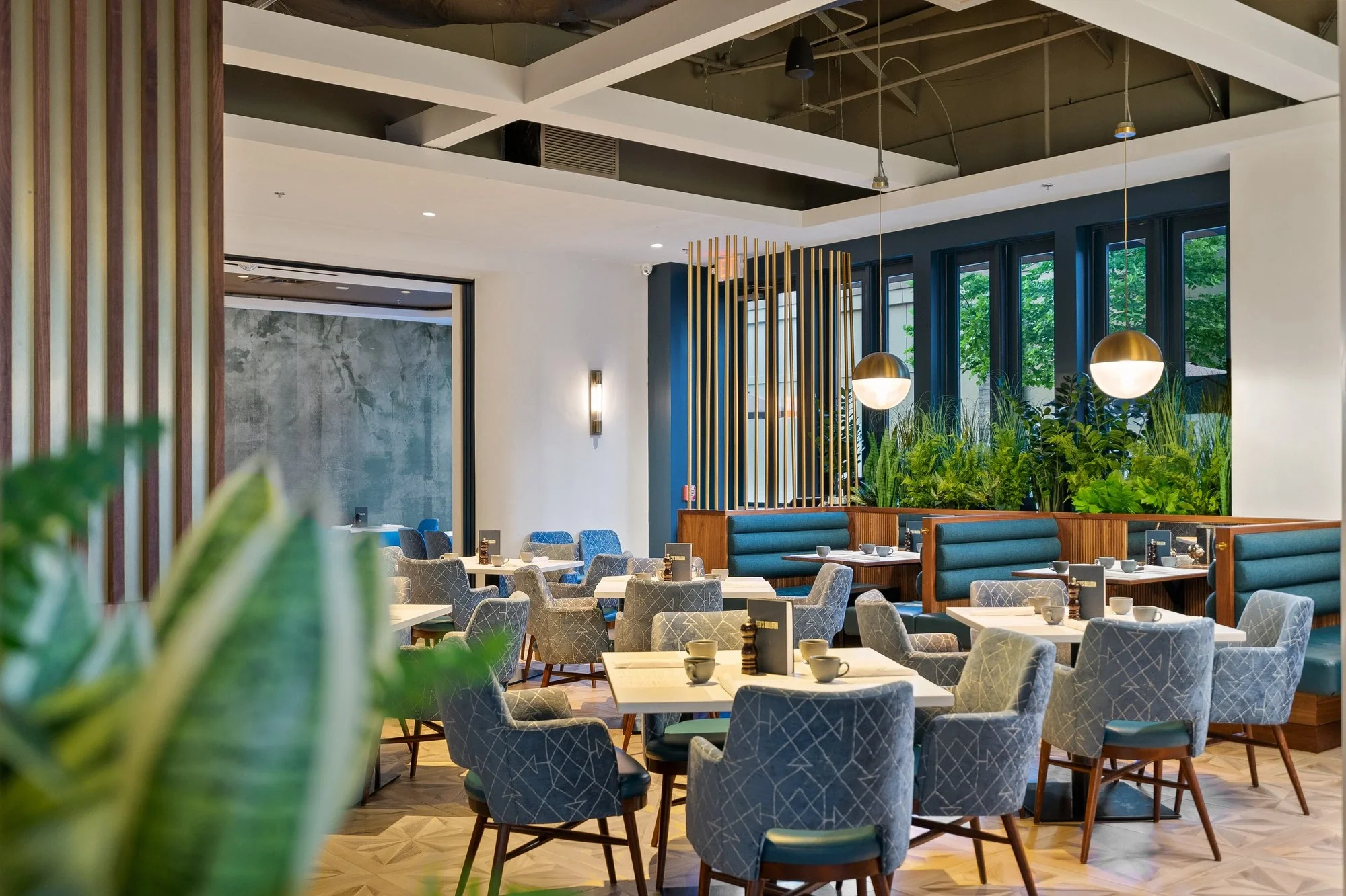 Modern restaurant dining room with booth seating and brass pendant lights — commercial interior photography by Umedia