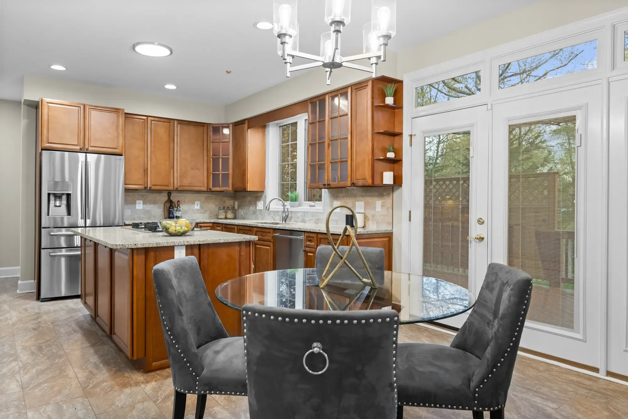 Professionally photographed bright kitchen and dining area with wood cabinetry and stainless steel appliances in a rental property
