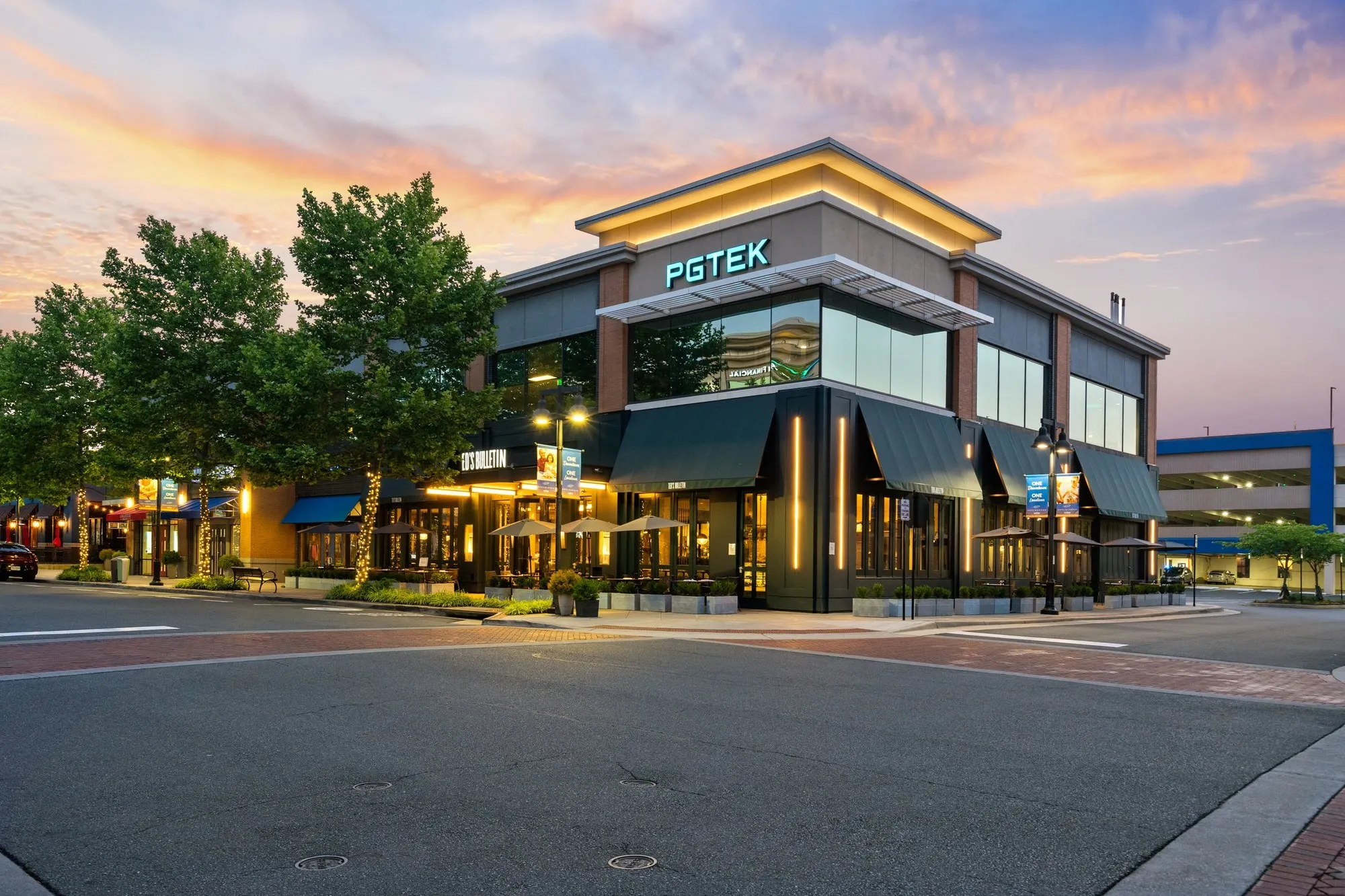 Twilight exterior of a mixed-use office building with ground-floor restaurant — commercial property photography by Umedia