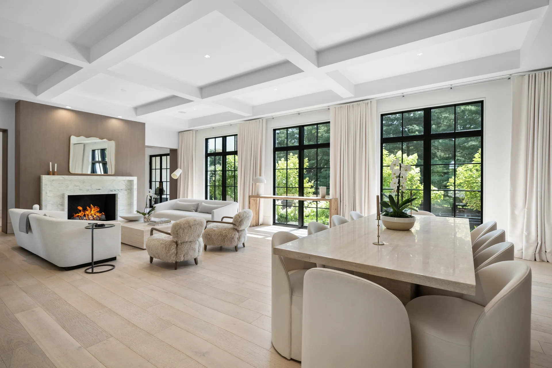 Matterport 3D virtual tour sample — open-concept living and dining room with coffered ceiling, fireplace, and floor-to-ceiling black-framed windows by Umedia