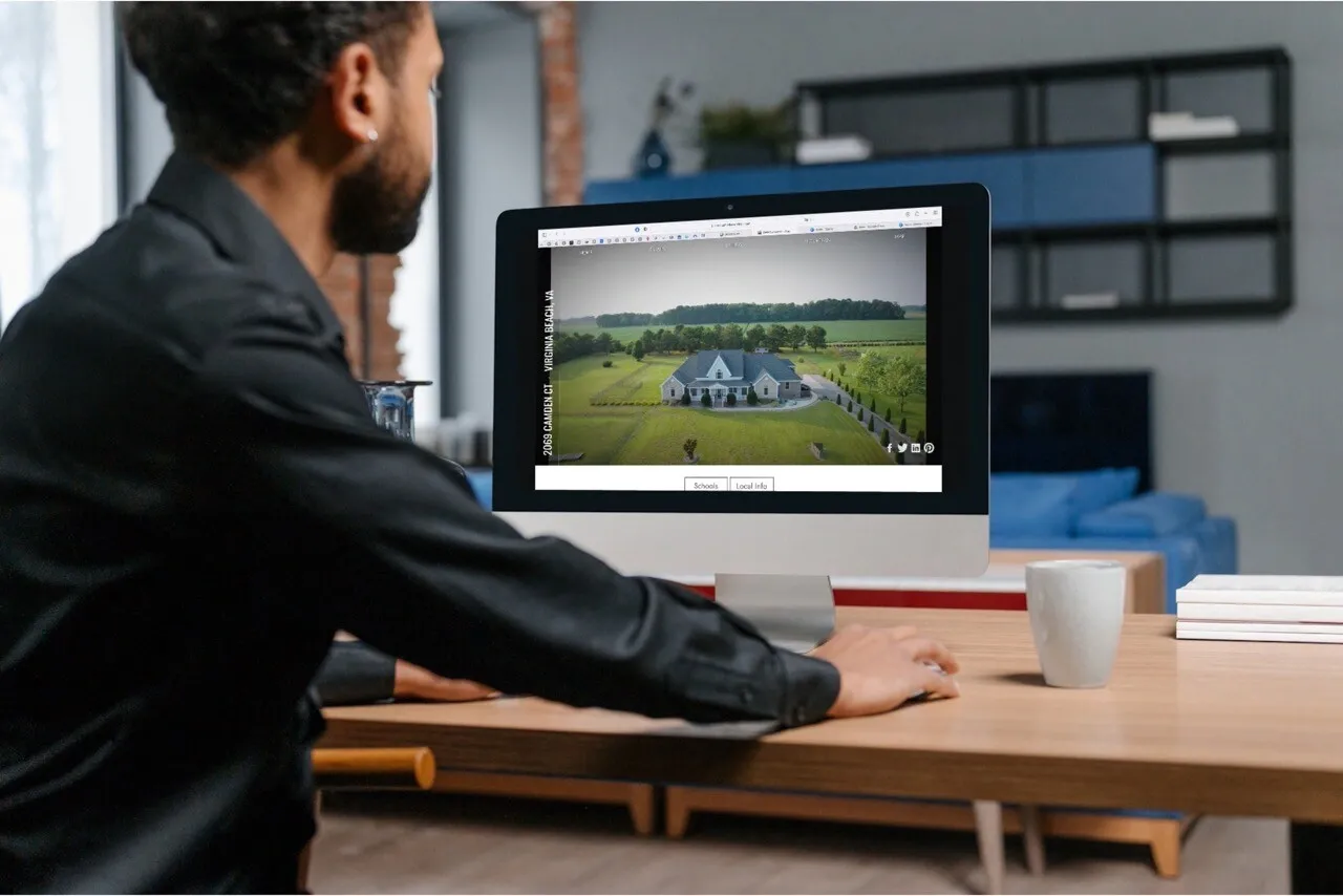Real estate agent reviewing a branded single-property listing website on a desktop monitor — property website design by Umedia