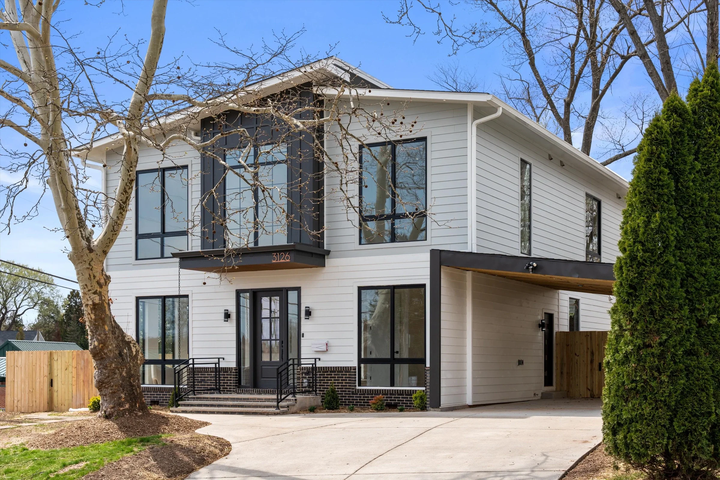 Modern new construction home exterior at 3126 Westley Rd Falls Church Virginia with white siding and black-framed windows by Umedia