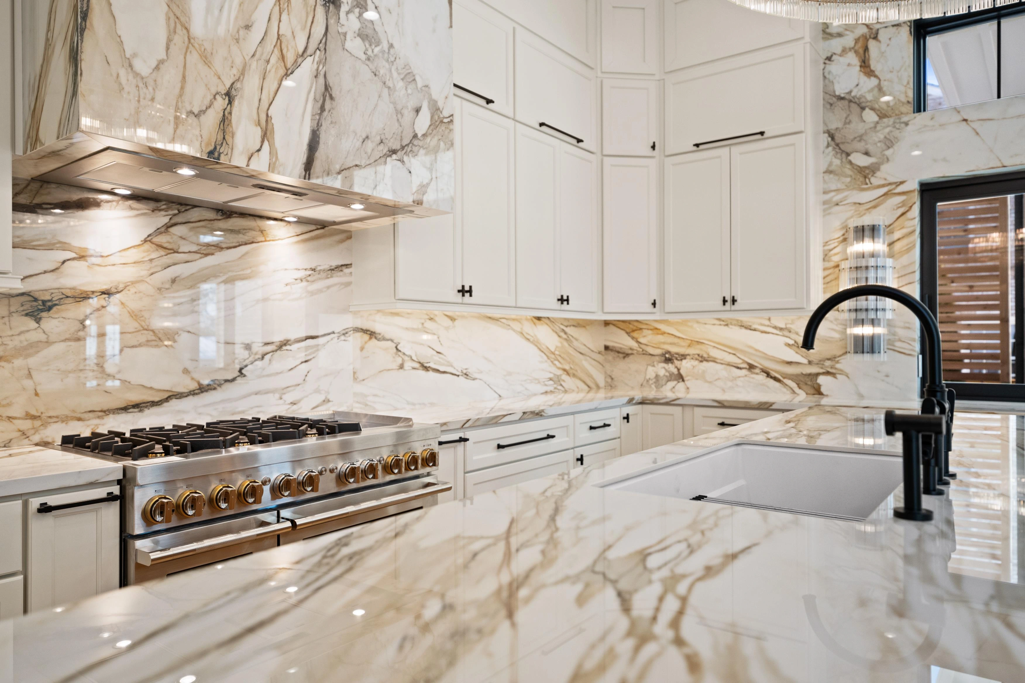 Professional gas range with calacatta marble backsplash and black fixtures